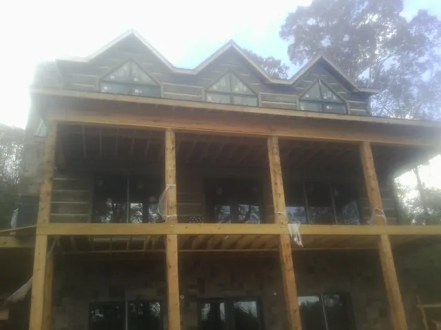 Dormers and porch framing on a large log home under construction — Roof Coating work by our crew in Russellton