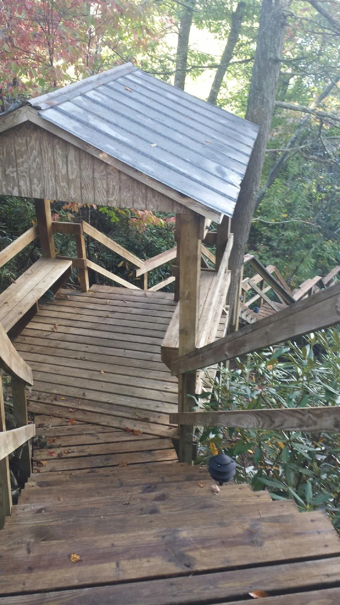 Metal roofed shelter over wooden steps on a wooded walkway — Skylight Repair & Installation work by our crew in Russellton