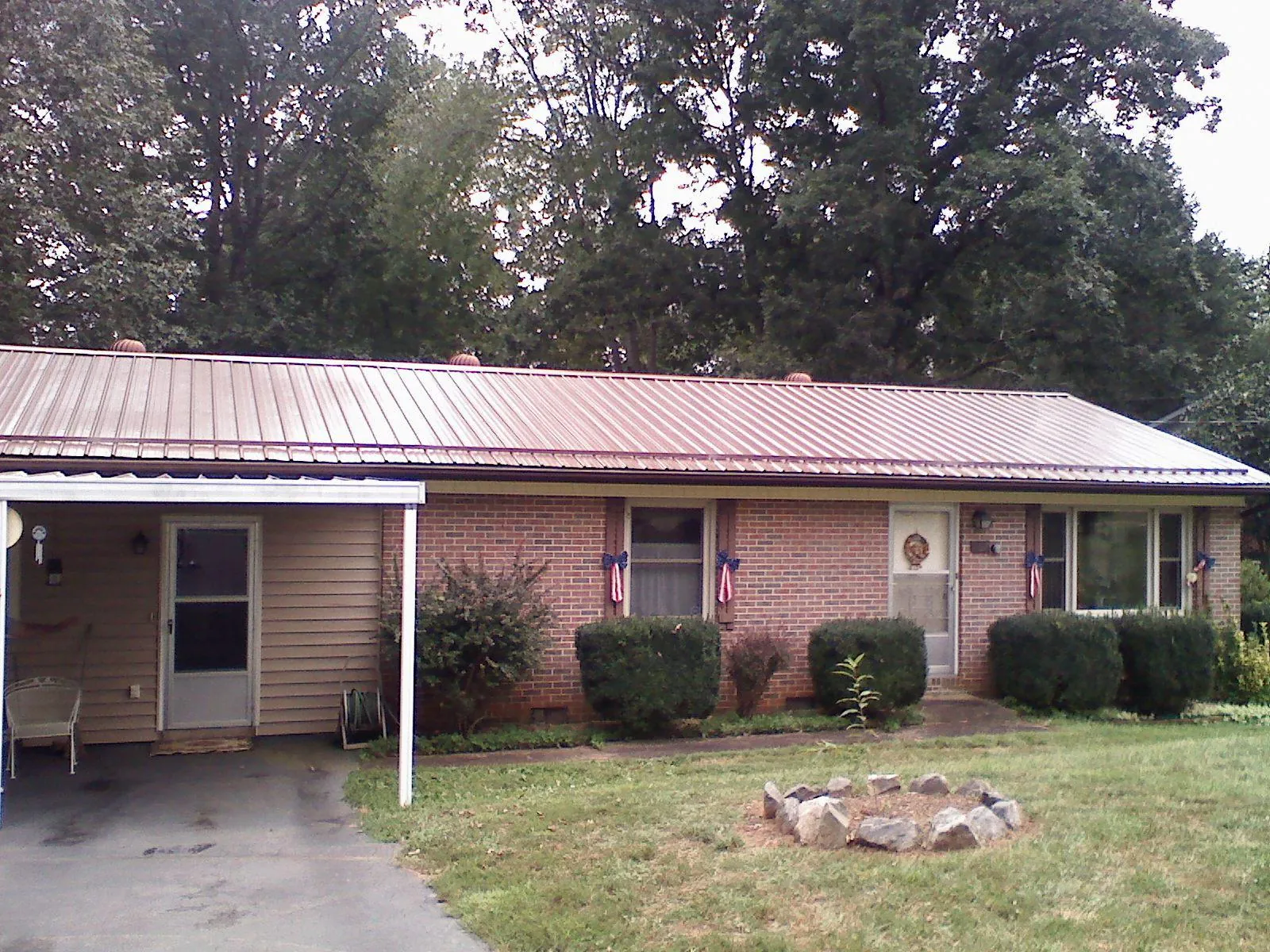 Bronze metal roof and carport on a brick ranch home — Roof Repair work by our crew in Russellton